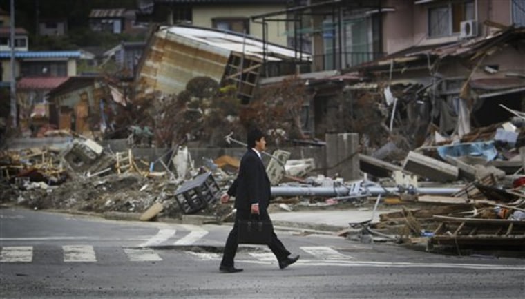 A man strolls in an area devastated by the March 11 earthquake and tsunami in Kesennuma, Miyagi Prefecture, northeastern Japan, on Thursday.
